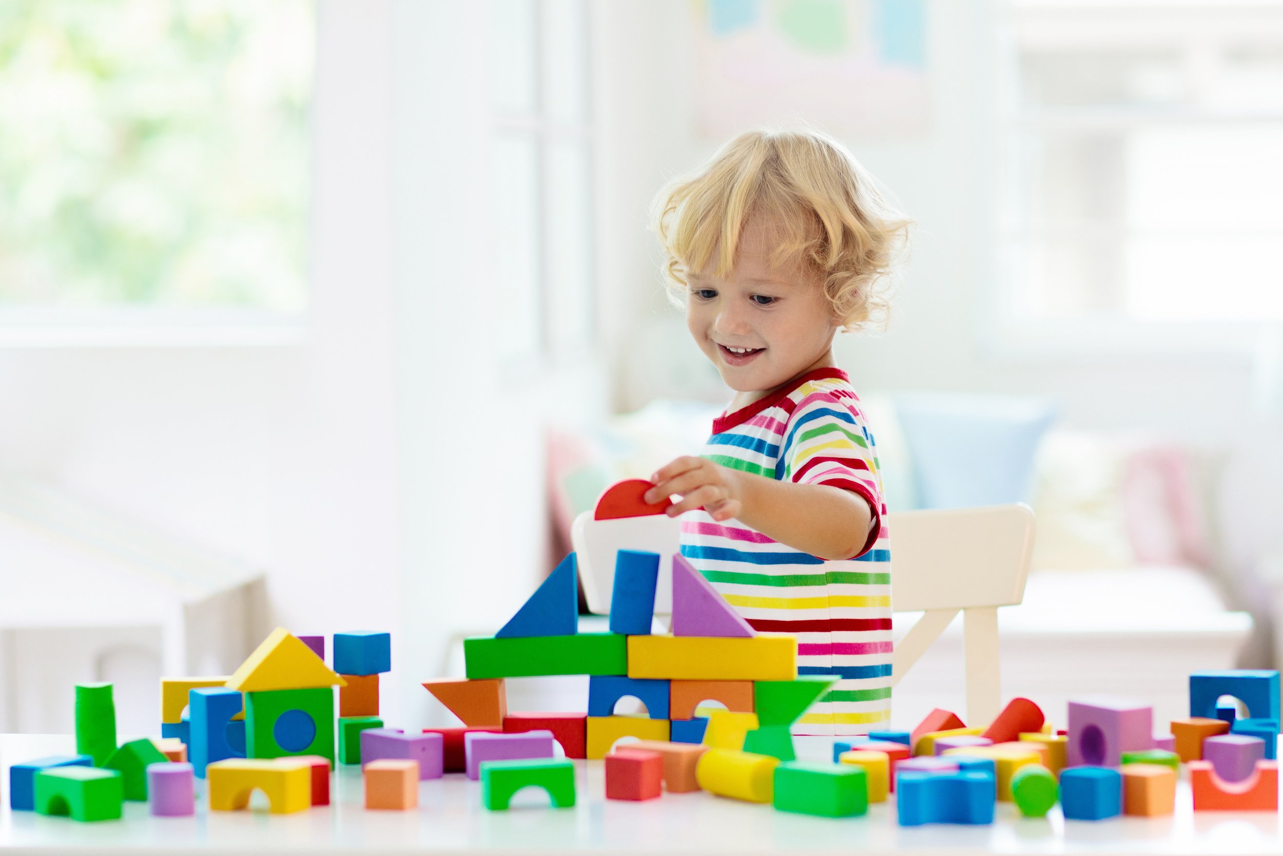 Kids toys. Child building tower of toy blocks.